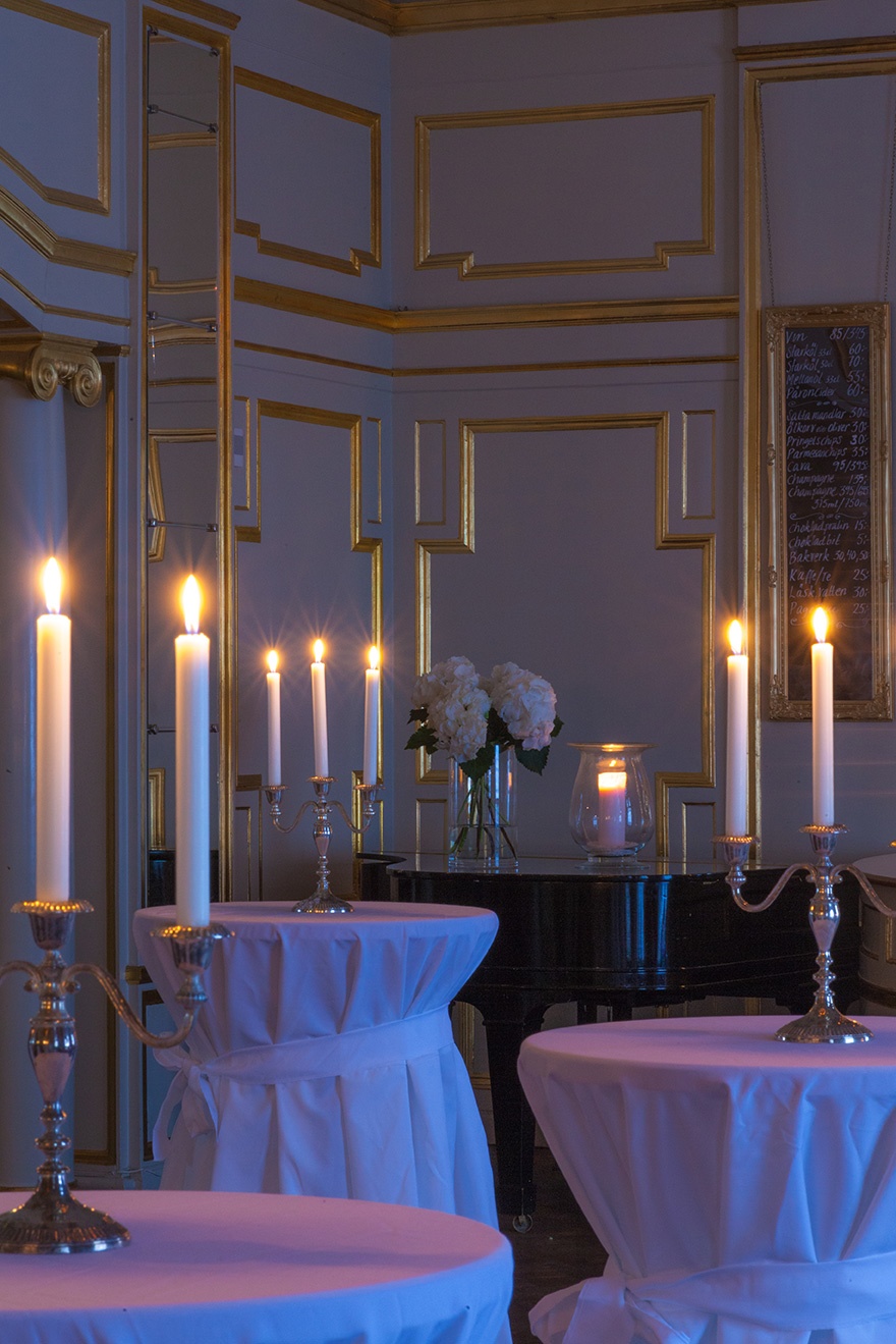 Bild på Oscarsteaterns guldfoaje med kandelaber på varje bord med tända ljus